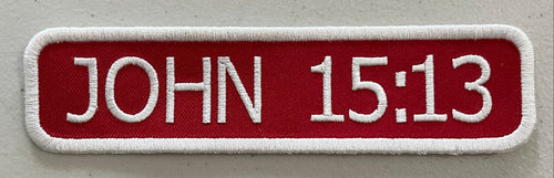 A custom embroidered patch on red background with white stitching.